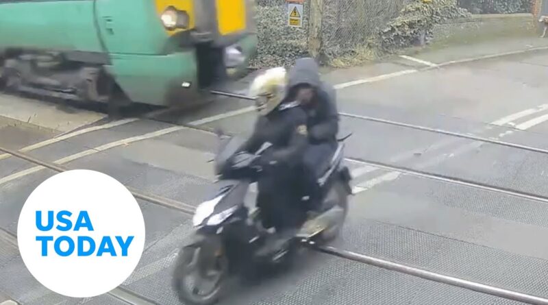 Close call! Moped driver almost narrowly avoids getting hit by train | USA TODAY